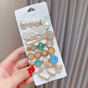 Detail of 8-piece pearl hair clip set with resin heart and sequin fishtail charms