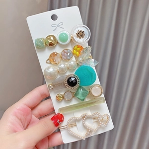 Detailed view of an 8-piece pearl hair clip set with resin and shell shapes on a card