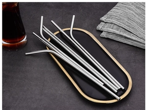 Polished silver stainless steel straight and curved straws on a decorative black tray