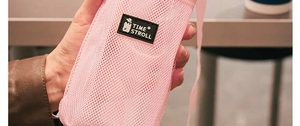 Pink mesh water bottle carrier with adjustable strap and TIME STROLL label close-up