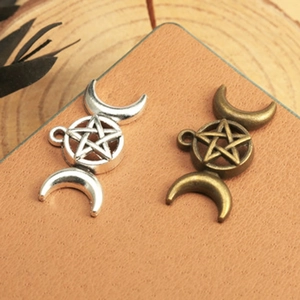 Detail of silver and bronze triple goddess moon and pentagram alloy pendant charms