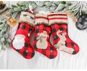 Detail of red and black plaid Christmas stockings with plush trim and holiday figures
