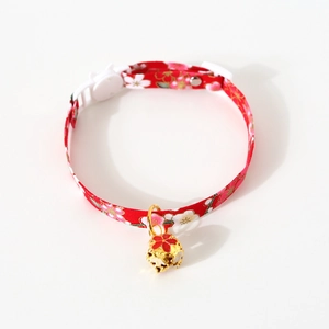 Detail of adjustable pet collar with red cherry blossom pattern and golden bell