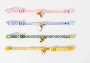 Detail view of colorful pet collars with star patterns and cute fruit-shaped pendants