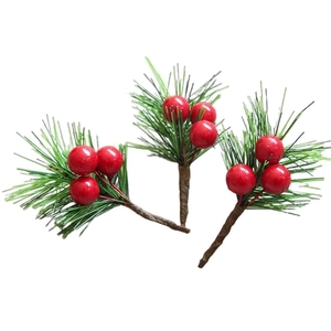 Detailed view of three artificial pine needle branches with vibrant red berries for decor
