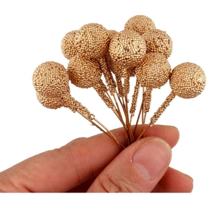 Close-up of mini gold berry ornaments with sparkling beads and flexible wire stems