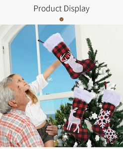 Détail de chaussettes de Noël à carreaux rouges et noirs avec rennes et flocons blancs