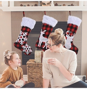 Détail de trois chaussettes de Noël à carreaux rouges et noirs avec bordure en peluche blanche