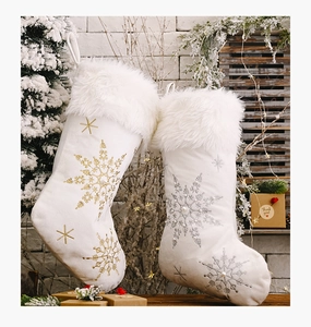 Close-up of plush Christmas stockings with snowflake embroidery and pearl details