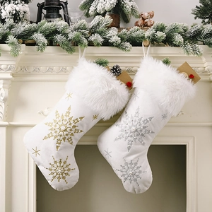 Detail of plush Christmas stockings with gold and silver snowflake embroidery on mantel