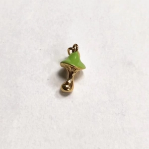 Close-up of golden mushroom pendant with green enamel finish and connector ring