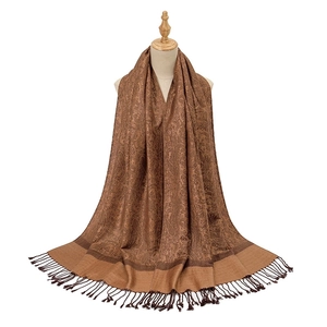Detail of brown paisley acrylic scarf featuring soft fabric texture and fringe tassels