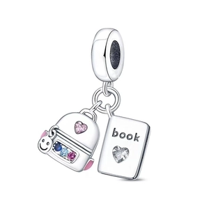 Macro detail of silver charm featuring a book and crystal backpack pendant