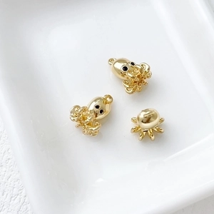 Three 14k gold plated octopus pendants in a white ceramic dish for DIY jewelry making