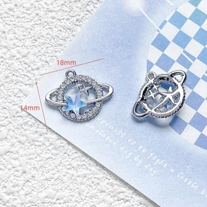 Detail showing 18x14mm silver planet pendant with blue star and white crystals