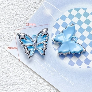 Macro view of blue butterfly charm showing 23mm x 20mm dimensions and silver edges