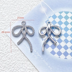 Detailed view of silver bow-shaped DIY charms in 21mm and 29.5mm sizes with crystal inlay