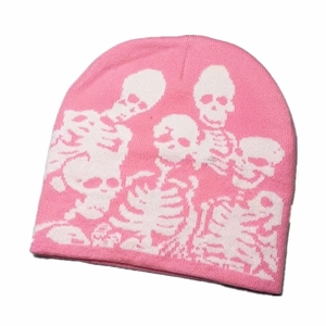 Detailed close-up of a pink knitted beanie with a white skeleton bone pattern