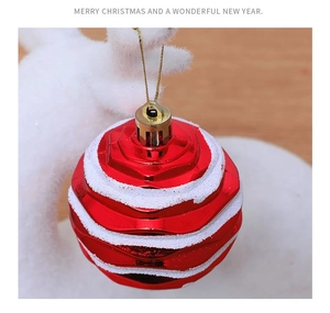 Close-up of red Christmas ball ornament with white frosted stripes and golden string