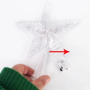 Installation detail of clear star tree topper with LED light and battery box