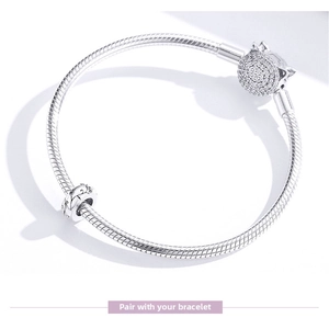 Detail of S925 sterling silver snake chain bracelet with hollow pattern charm and paved clasp