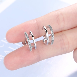 Minimalist silver semi-circle hoop earrings with inlaid crystals on a polished metal band