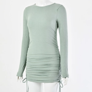 Detail of mint green ribbed knit dress featuring adjustable side drawstrings and ruching