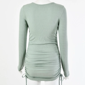 Back view of green ribbed knit dress on mannequin showing drawstring and ruched details