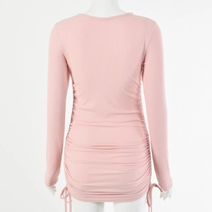 Detail view of pink ribbed knit texture with adjustable drawstring ruching on a slim dress