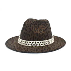Détail d'un chapeau fedora léopard avec trois rangées de garnitures de perles blanches