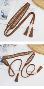 Detail of bohemian brown woven belt with lace patterns and fringe tassels