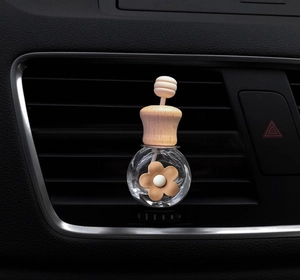 Close-up of a spherical glass car perfume bottle with wooden lid on air vent