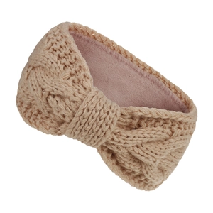 Detail of cable knit headband with warm pink fleece lining and beige yarn texture