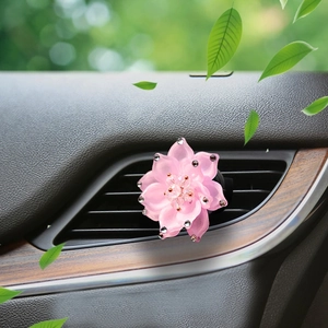 Macro shot of pink rhinestone lotus flower car aromatherapy clip on vent outlet