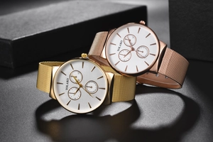 Close-up of gold and rose gold quartz watches with Milanese mesh bands and white dials