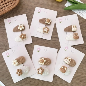 2Pcs plush cartoon rabbit and star hair clips set for kids on a wooden desk