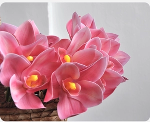 Close-up of realistic pink 3D printed cymbidium orchid in a rustic woven flower basket