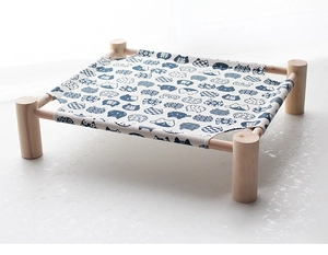Detail of wooden pet hammock featuring blue canvas with cat patterns and sturdy timber frame