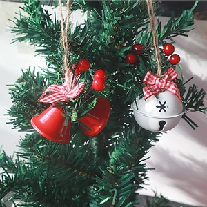 Christmas tree ornaments featuring red bells, white bells, plaid bows and pine berries