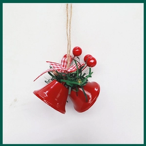 Close-up of red metal Christmas bells with a red checked bow and holly berry decorations