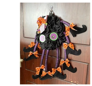 Detailed view of Halloween spider wreath with purple striped legs and witch boots on a door