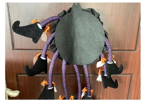 Detailed back view of Halloween witch leg door wreath with black felt and hanging hole