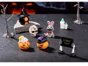 Miniature Halloween figures featuring ghosts, pumpkins, and a zombie party sign on display