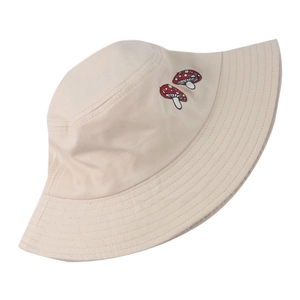 Gros plan du chapeau de pêcheur beige avec broderie de champignon rouge sur toile coton
