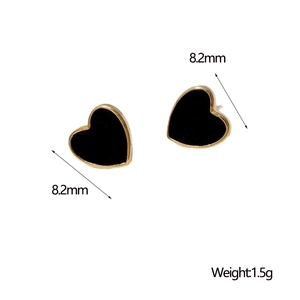 Macro detail of 8.2mm black heart earrings with gold trim showing exact size and weight