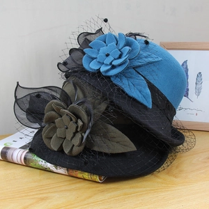 Detail of wool felt cloche hat with floral mesh veil and elegant rolled brim decoration