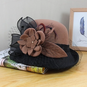 Detail of vintage wool felt hat featuring brown and black mesh flower and feather accents
