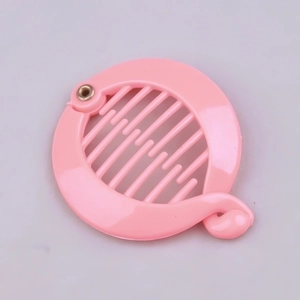 Detail of a pink circular hair clip showing the internal plastic teeth and metal hinge