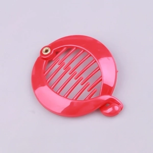 Detail shot of a bright red plastic round banana hair clip with a smooth glossy finish