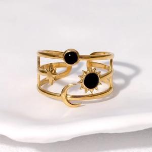 Gold celestial open ring with sun, moon, and star charms featuring black stone accents